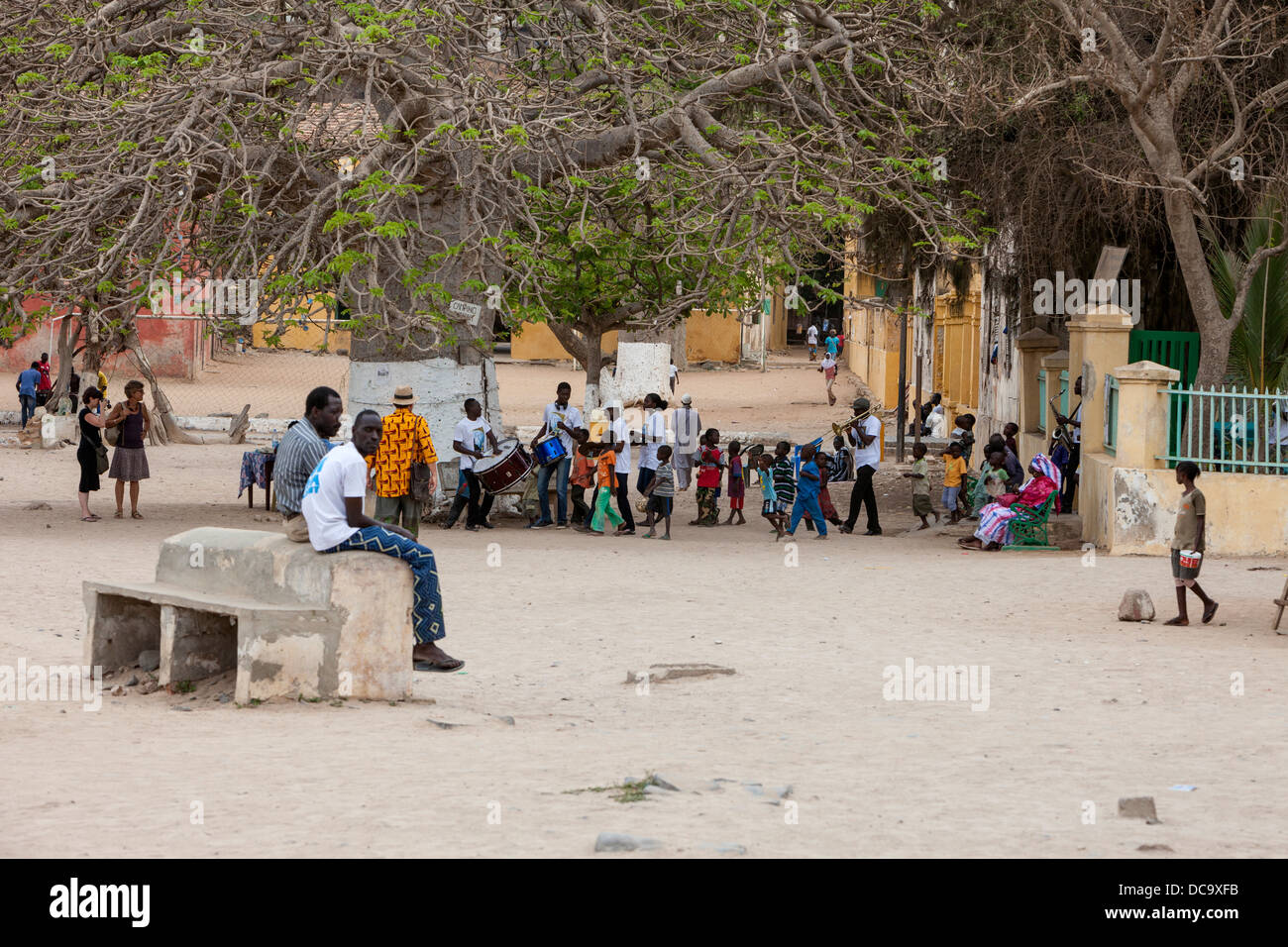 Central Plaza, Musiker, spielen, Kinder folgend Goree Island, Senegal. Stockfoto