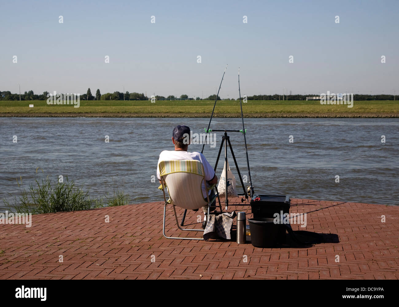 Man Fishing River Maas, Alblasserdam, Rotterdam, Niederlande Stockfoto