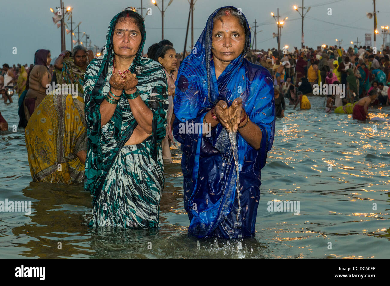 Frauen, die ein Bad in der Sangam, dem Zusammenfluss der Flüsse Ganges und Yamuna Saraswati, in den frühen Morgenstunden Kumbha Mela Stockfoto