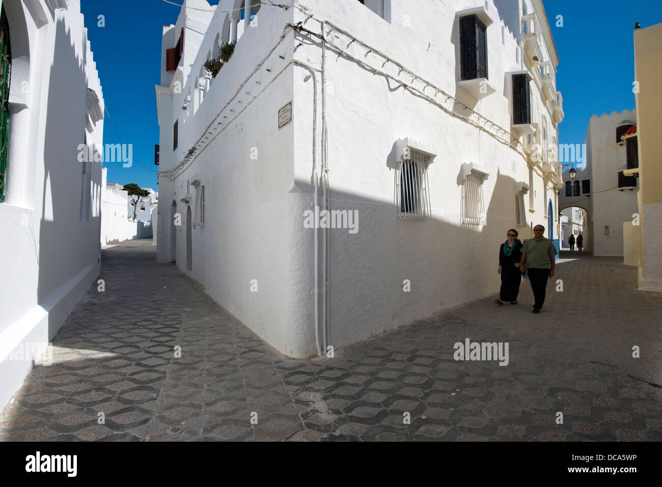 Ein Mann und eine Frau Fuß auf einer Straße in der Küstenstadt Stadt Asilah, Marokko. Stockfoto