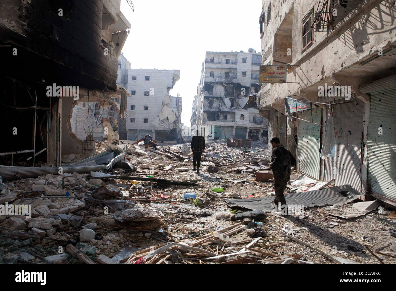 29. November 2012 - Aleppo, Syrien: Freie Syrische Armee Kämpfer zu Fuß durch den Krieg verwüsteten Straßen in Amaria. Stockfoto