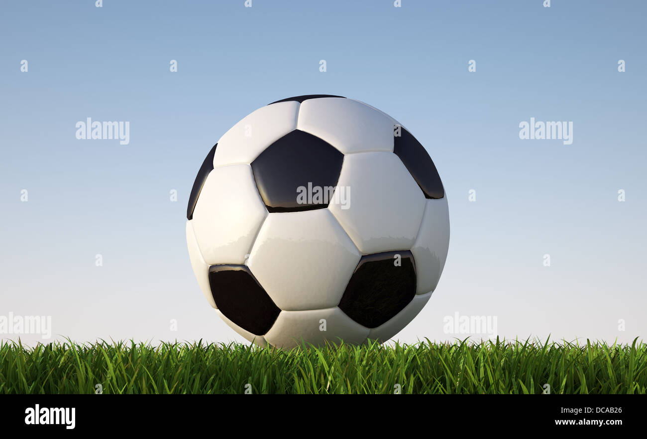 Fußball hautnah auf Rasen. Vom Boden aus betrachtet. Im sonnigen Tageslicht. Mit blauem Himmel und keine Wolken im Hintergrund. Stockfoto