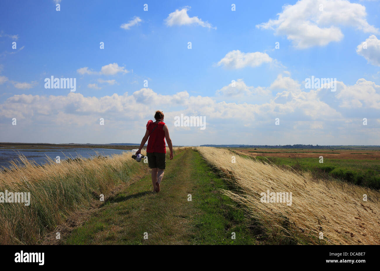 Frau zu Fuß die North Norfolk Küstenweg in Burnham Deepdale. Stockfoto