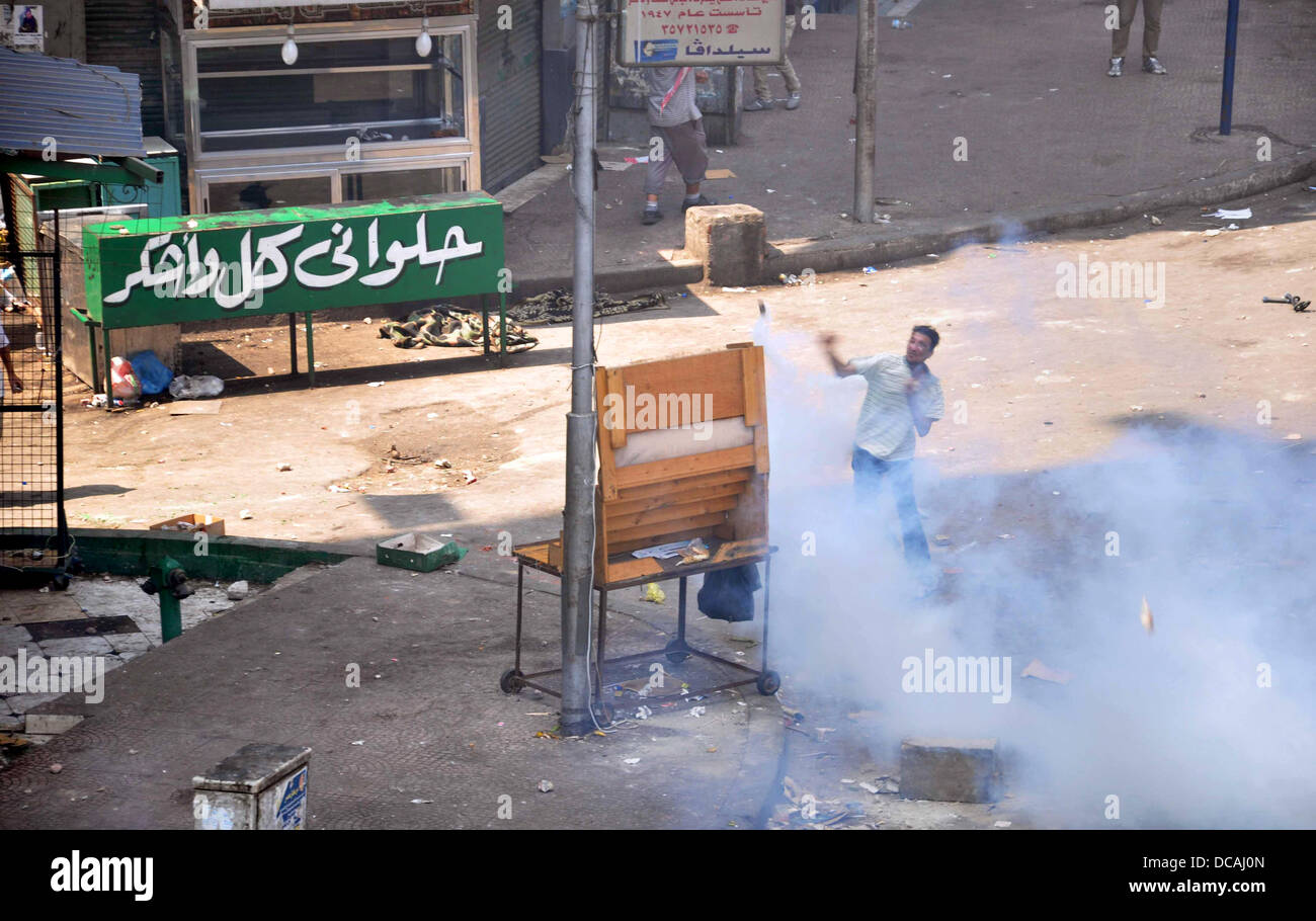 Kairo, Ägypten. 14. August 2013. Anhänger des gestürzten Präsidenten Mohamed Morsi Zusammenstoß mit ägyptische Bereitschaftspolizei auf einer Straße zur Rabaa al-Adawiya-Platz in Kairo am 14. August 2013 als Sicherheitskräfte unterstützt durch Planierraupen zog auf zwei großen Pro-Mursi-Protestcamps startet eine lange bedroht durchgreifen, die Dutzende Tote. Die Operation begann kurz nach Sonnenaufgang, als Sicherheitskräfte die weitläufige Rabaa al-Adawiya Camp in Ost-Kairo und einem ähnlichen am Al-Nahda-Platz im Zentrum der Hauptstadt Credit umgeben: Ahmed Asad/APA Images/ZUMAPRESS.com/Alamy Live News Stockfoto