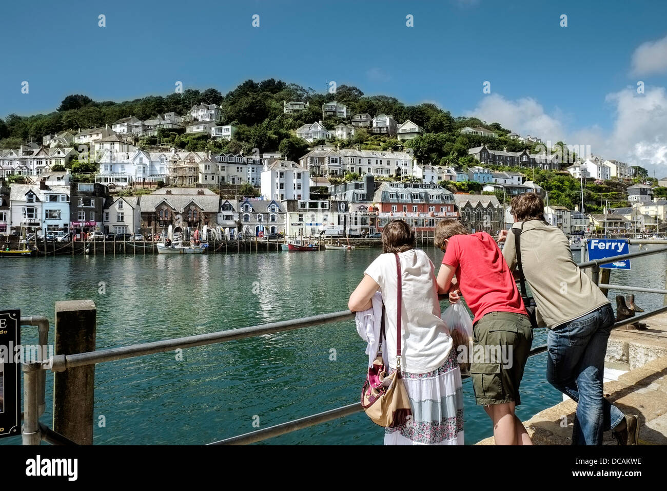 Eine Familie genießen den Blick auf den Kai von Looe. Stockfoto