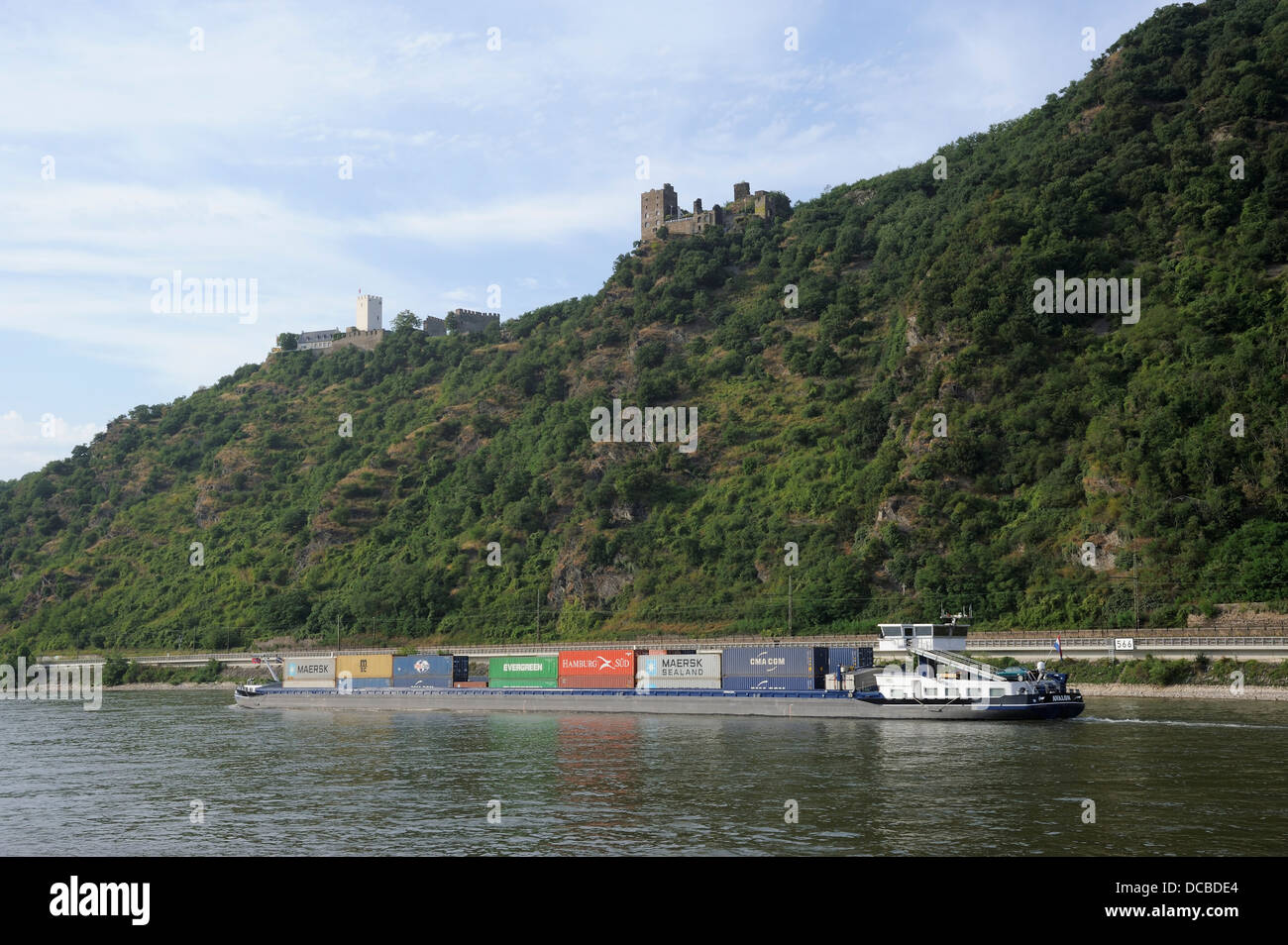 Containerschiff und Burgen gesehen vom Rhein Tal Boot Kreuzfahrt Stockfoto