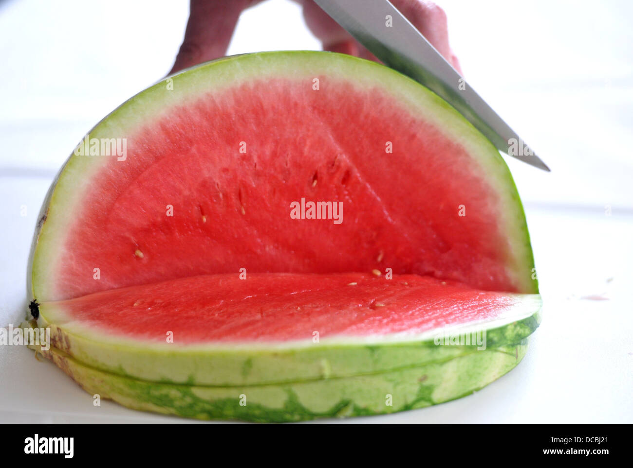 Jemand eine Wassermelone schneiden Stockfoto