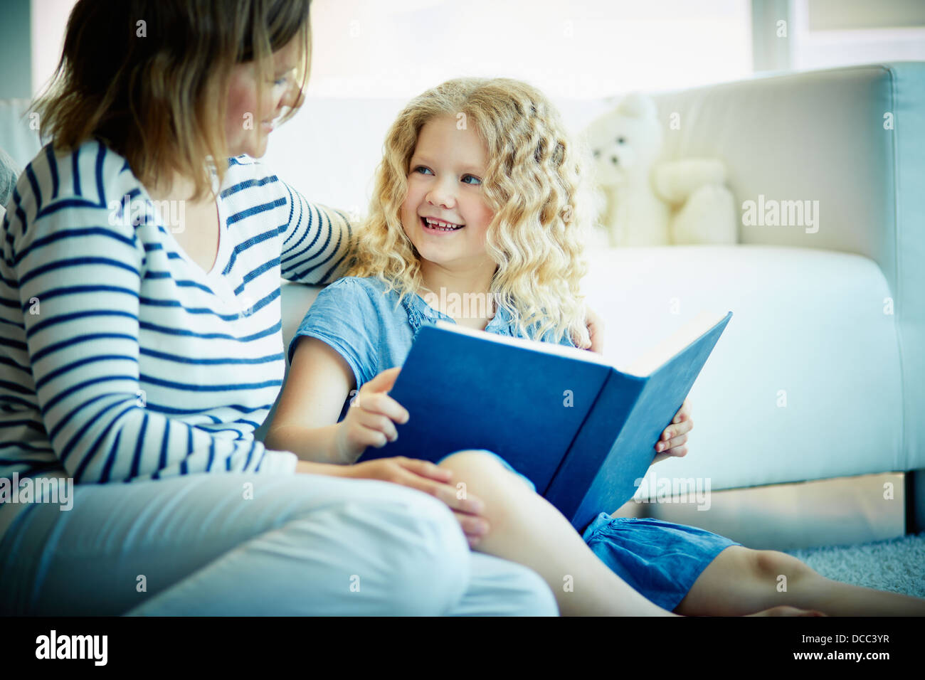 Porträt von netten Mädchen Blick auf ihre Mutter während der Diskussion über eine interessante Geschichte zu Hause Stockfoto