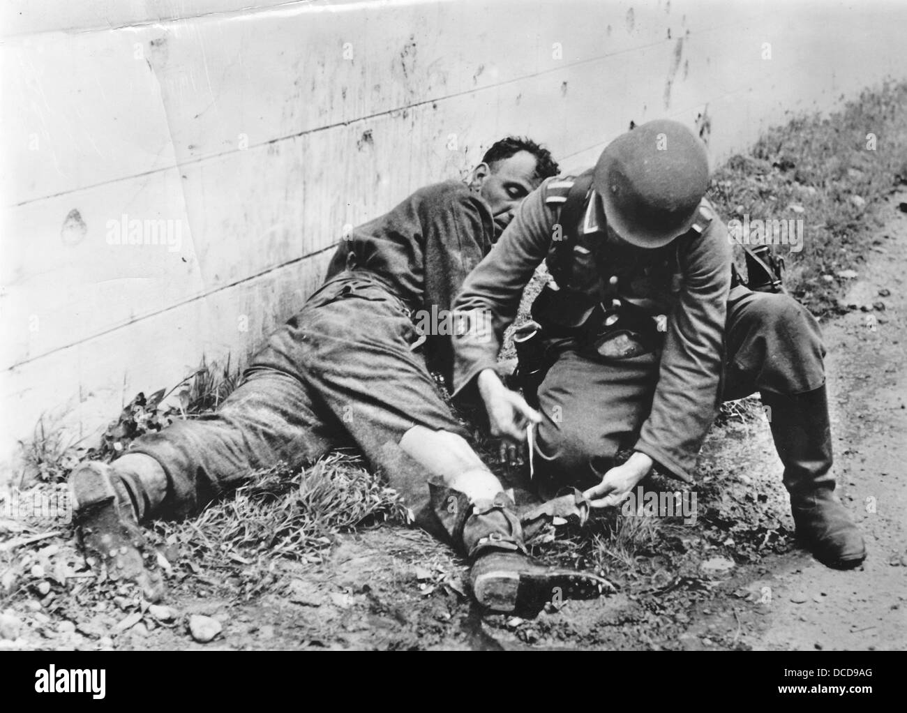 Ein Mitglied des Ärztekorps (Rod of Asclepius auf der Uniform) der deutschen Wehrmacht leistet während der sogenannten Operation Jubilee (Dieppe RAID) in Dieppe, Frankreich, im Sommer 1942 erste Hilfe. Fotoarchiv für Zeitgeschichte Stockfoto