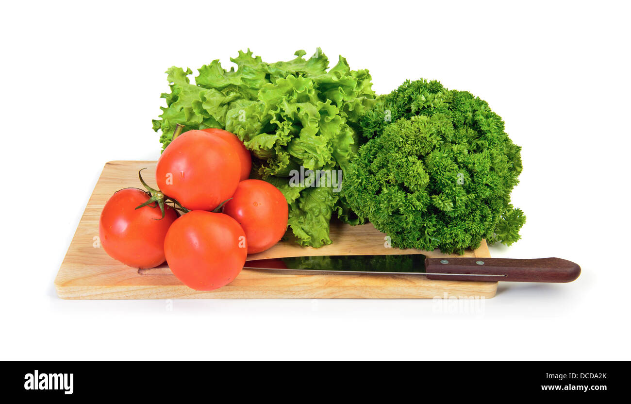 Rote Tomaten, Kopfsalat, Petersilie auf geschnittene Brett mit Messer bereit, über weiß zu kochen Stockfoto