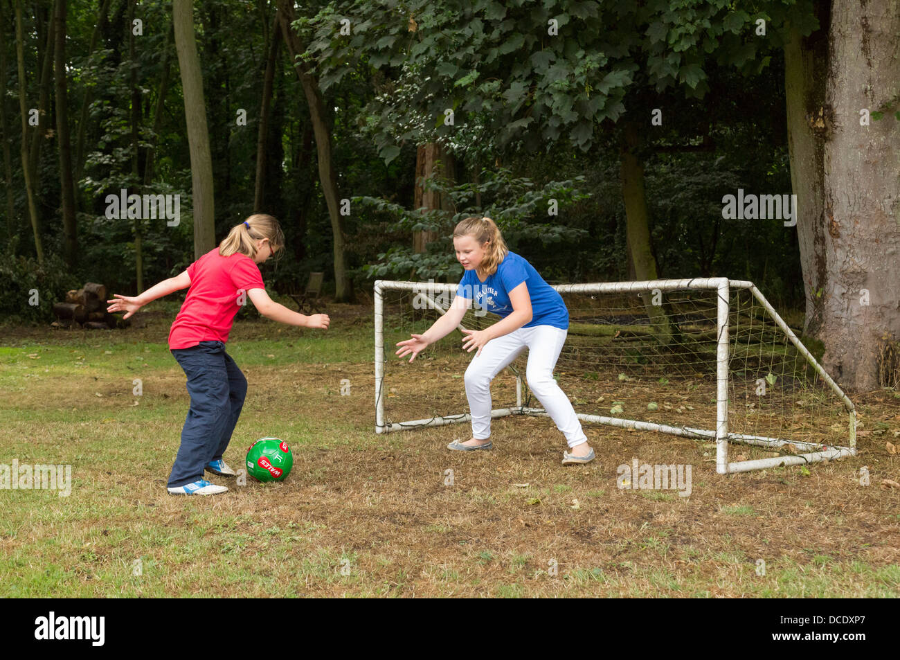 zwei junge Mädchen spielen Fußball im Hinterhof/Garten Stockfoto