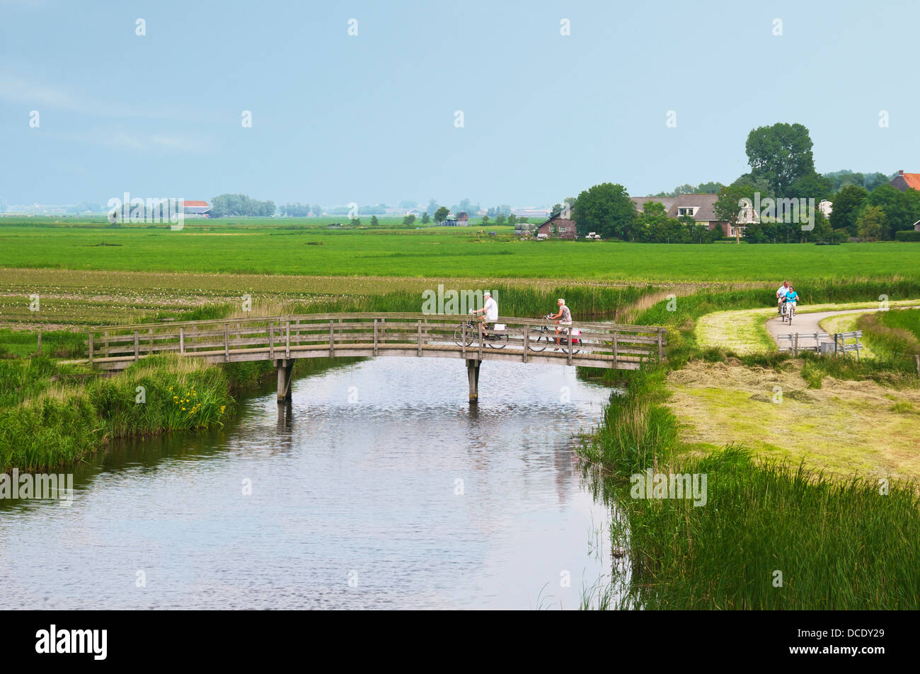 Radfahrer, die Holzbrücke Friesland Holland Kanal überqueren Stockfoto