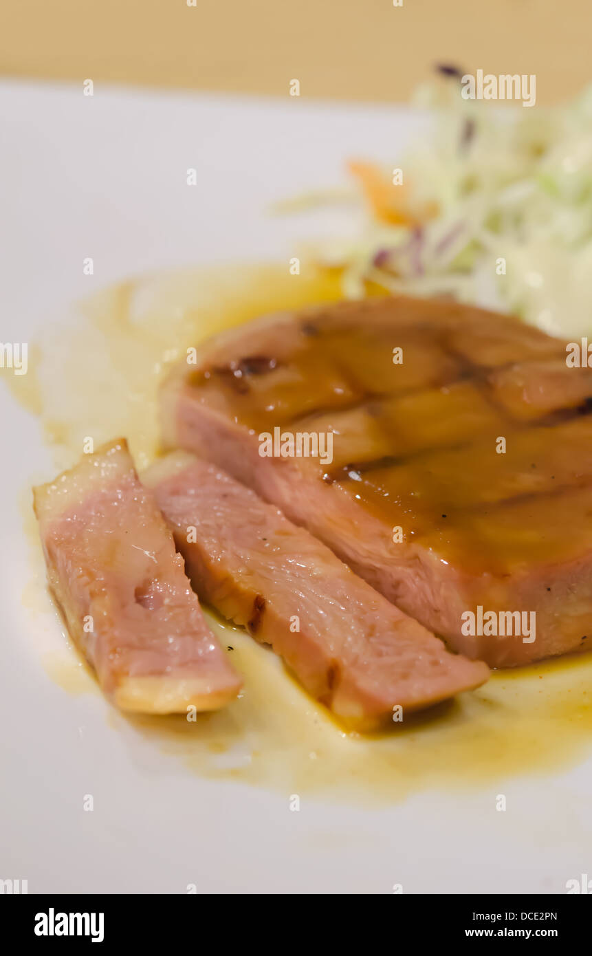 gebackener Schinken mit Soße Sauce auf weißen Teller geschnitten Stockfoto