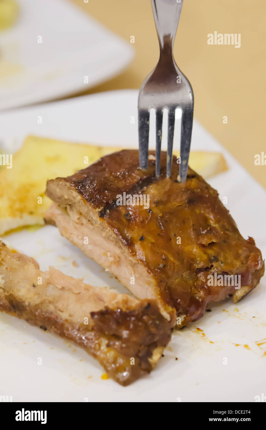Gegrilltes Schweinefleisch Baby Back Ribs mit Gabel und Knoblauchbrot Stockfoto