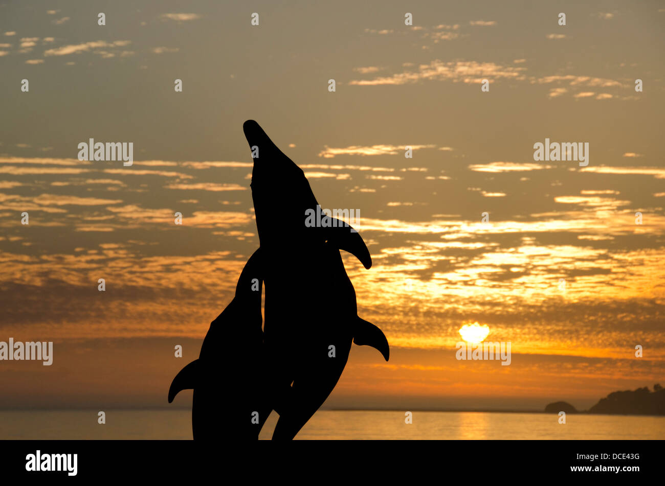 Kalifornien, Pacific Coast, Pismo Beach. Delphin-Skulptur-Silhouette mit Pazifischen Ozean Sonnenuntergang. Stockfoto