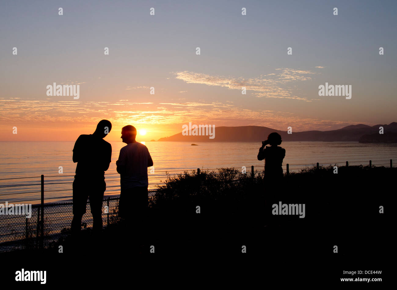 Kalifornien, Pacific Coast, Pismo Beach. Touristen genießen Sonnenuntergang über dem Pazifischen Ozean. Stockfoto