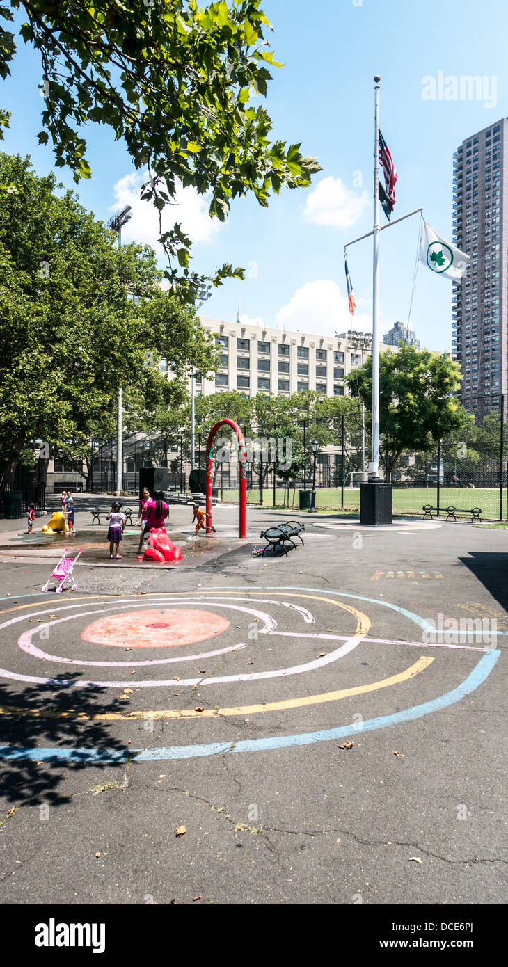 Flaggen wehen über DeWitt Clinton Park mit Baseball Felder Kinder spielen im Wasser-Funktion & bunte Kreide Labyrinth Hells Kitchen Stockfoto
