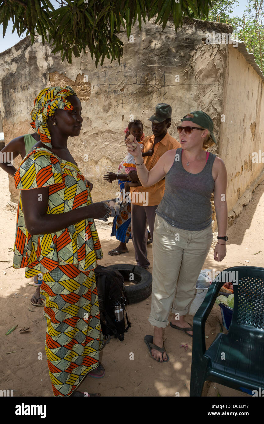 Senegalesische Frau geben freiwillig einen Peace Corps gekochte Ei, bevor sie auf eine Reise geht. Stockfoto