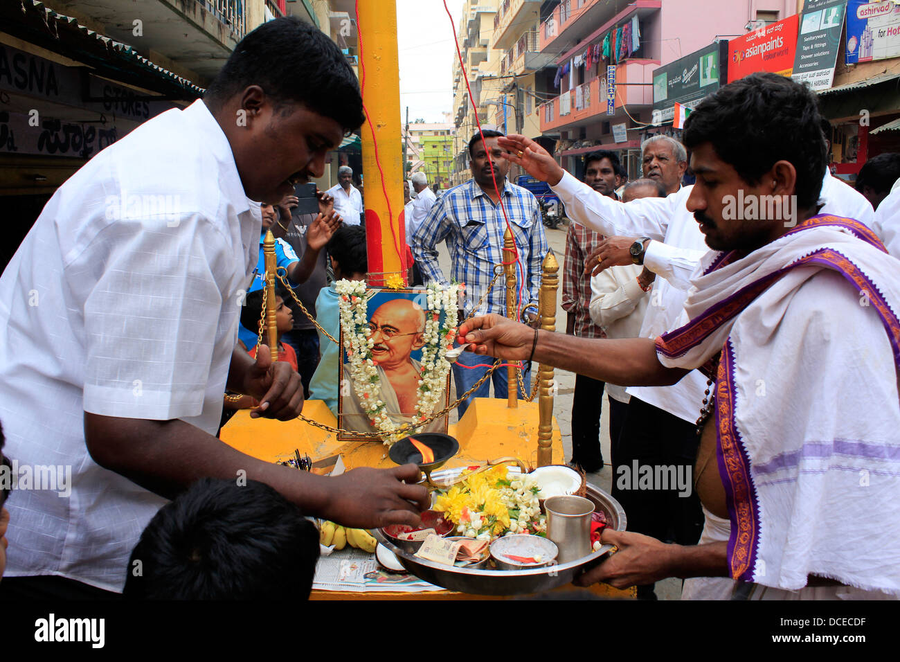 Menschen vor Ort in Bangalore feiert Unabhängigkeitstag vor einem Foto von Mahatma Gandhi Stockfoto