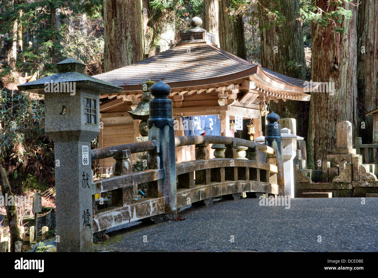 Naka no Hashi Holzbrücke, (mittlere Brücke), unter den Zedern auf dem gepflasterten Fußweg durch den japanischen alten Okunoin Friedhof bei Koya. Stockfoto