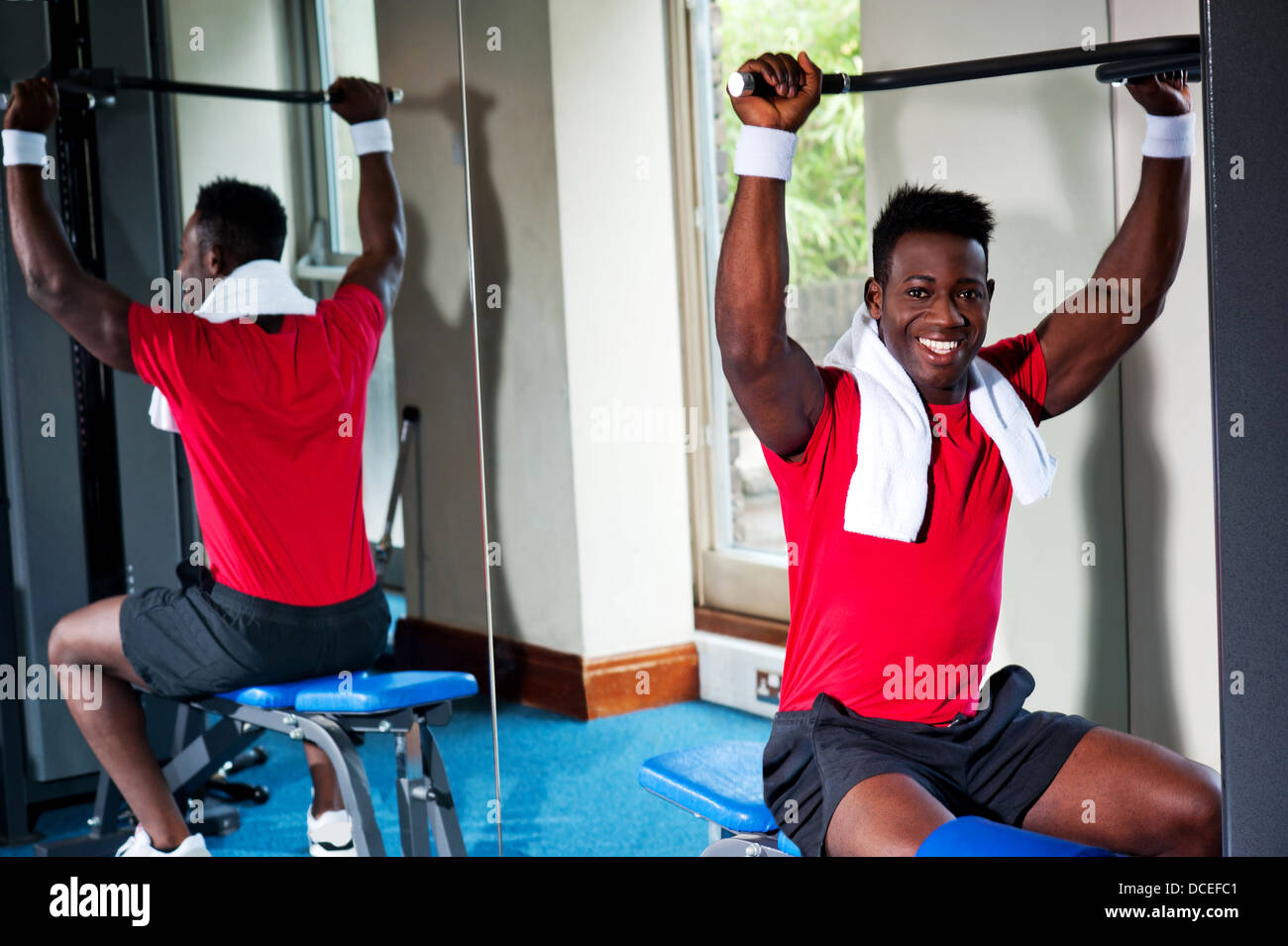 Fitness Guy trainieren Sie im Fitnessraum Tonen Oberteil Stockfoto