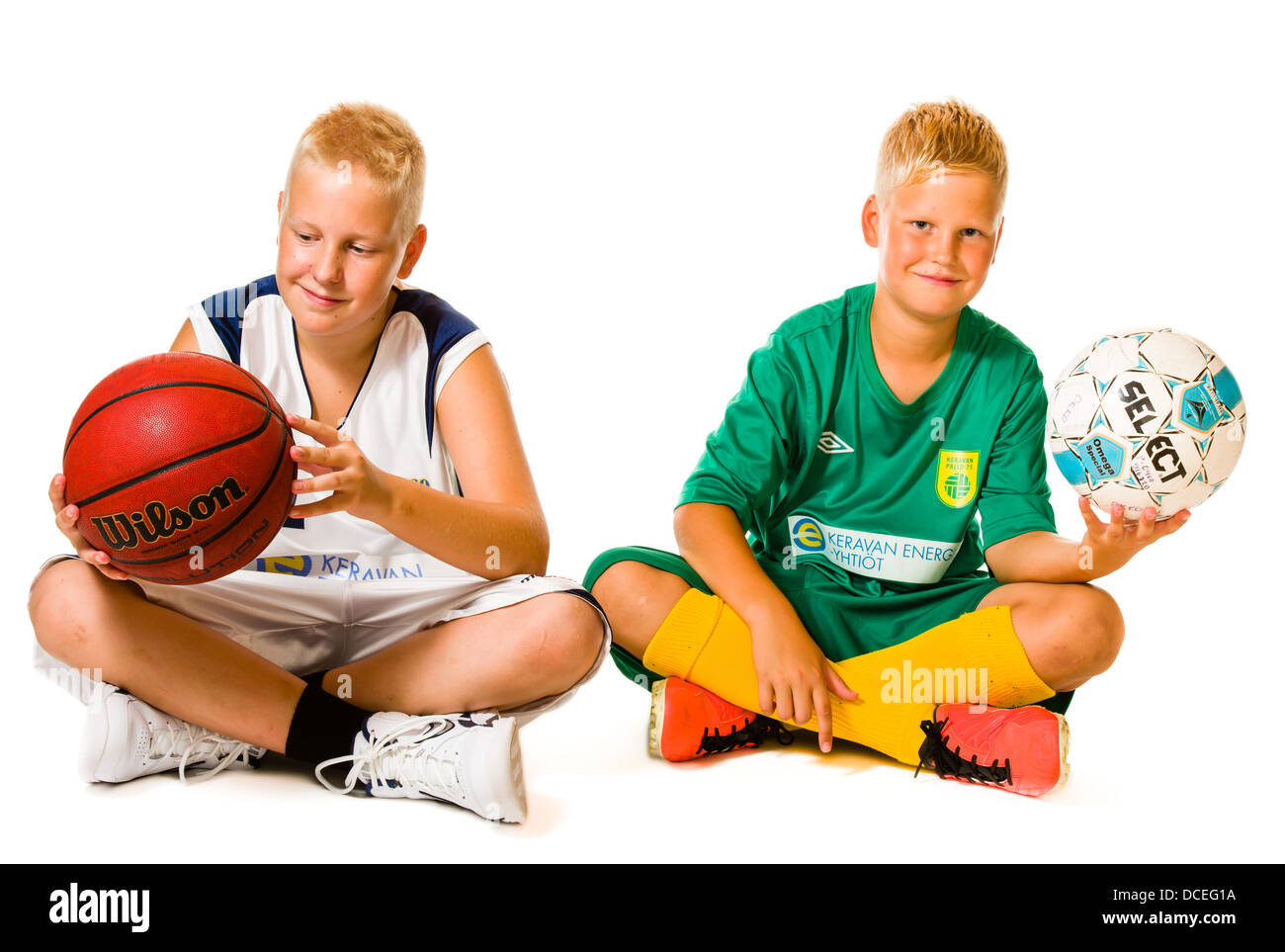 Brüder, junge Spieler sitzen zusammen auf Studio, weißer Hintergrund Stockfoto