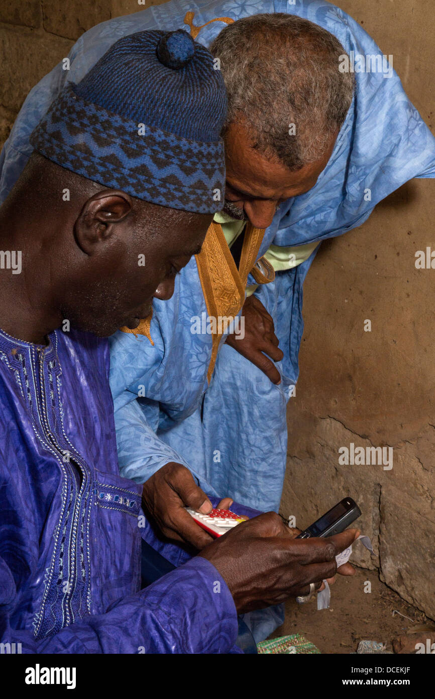 Cashew-Nuss Käufer überprüfen Berechnungen mit seiner Assistentin, Fass Njaga Choi, Gambia. Stockfoto