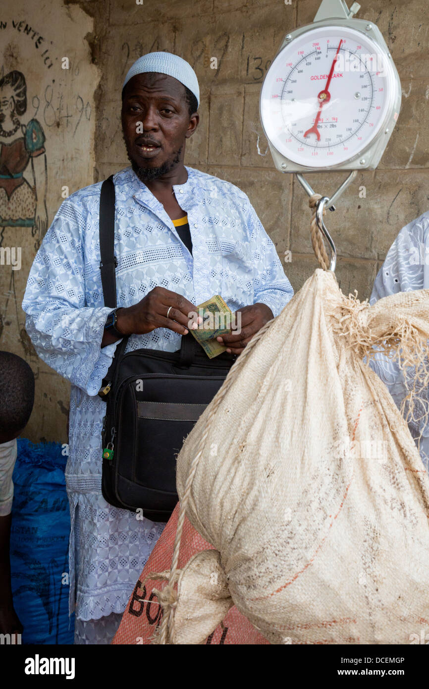 Cashew-Nuss-Käufer mit einem Gewicht von Nüssen, Fass Njaga Choi, Gambia. Stockfoto