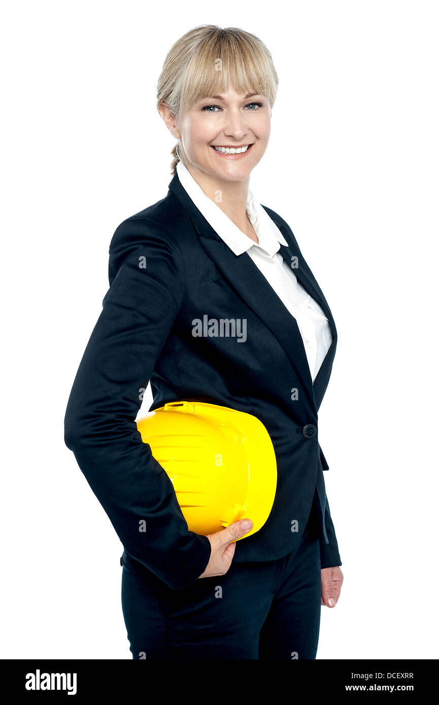Hübsches Geschäft Architekt mit gelben Helm in der Hand, zur Seite stehen und Lächeln auf den Lippen. Stockfoto