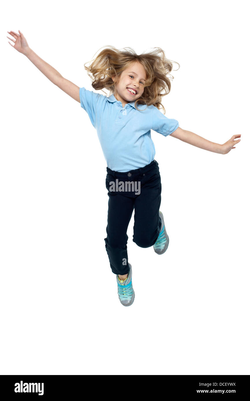 Schöne Mädchen springen hoch in die Luft, Arme seitlich ausgestreckt. Stockfoto