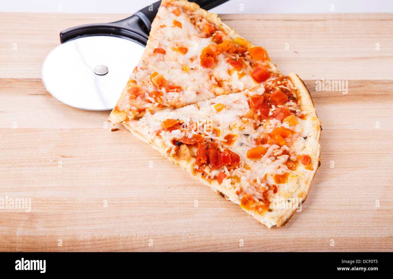 Scheiben von Tomaten Pizza auf ein Holz Schneidebrett mit Pizza schneiden whell Stockfoto