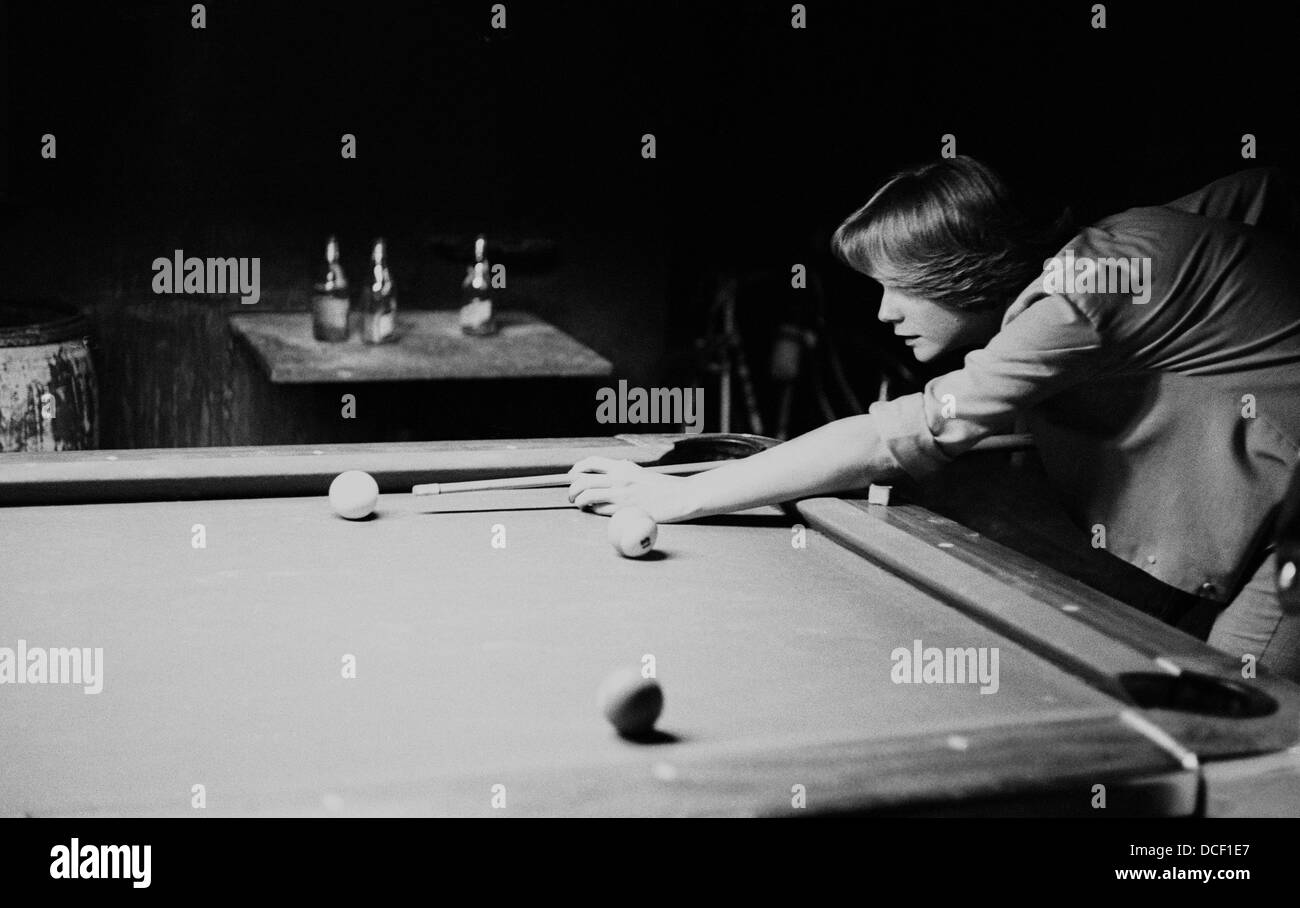 Ein einfarbig (schwarz-weiß) Bild einer Frau schießen Pool oder Billard in einer rustikalen Bar oder Pub-Ambiente. Stockfoto
