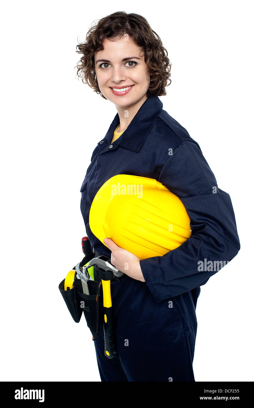 Junge glückliche Frau in Bau-Uniform mit gelben Helm. Stockfoto
