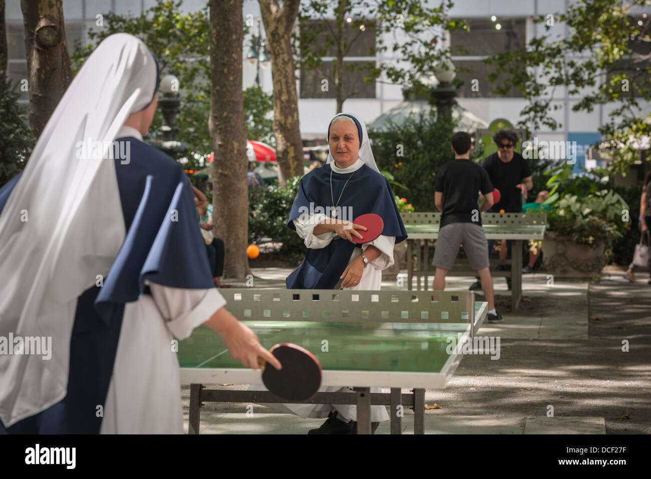 Nonnen von den Schwestern der Lebensordnung der katholischen Kirche spielen eine energetische Partie Tischtennis im Bryant Park in New York Stockfoto