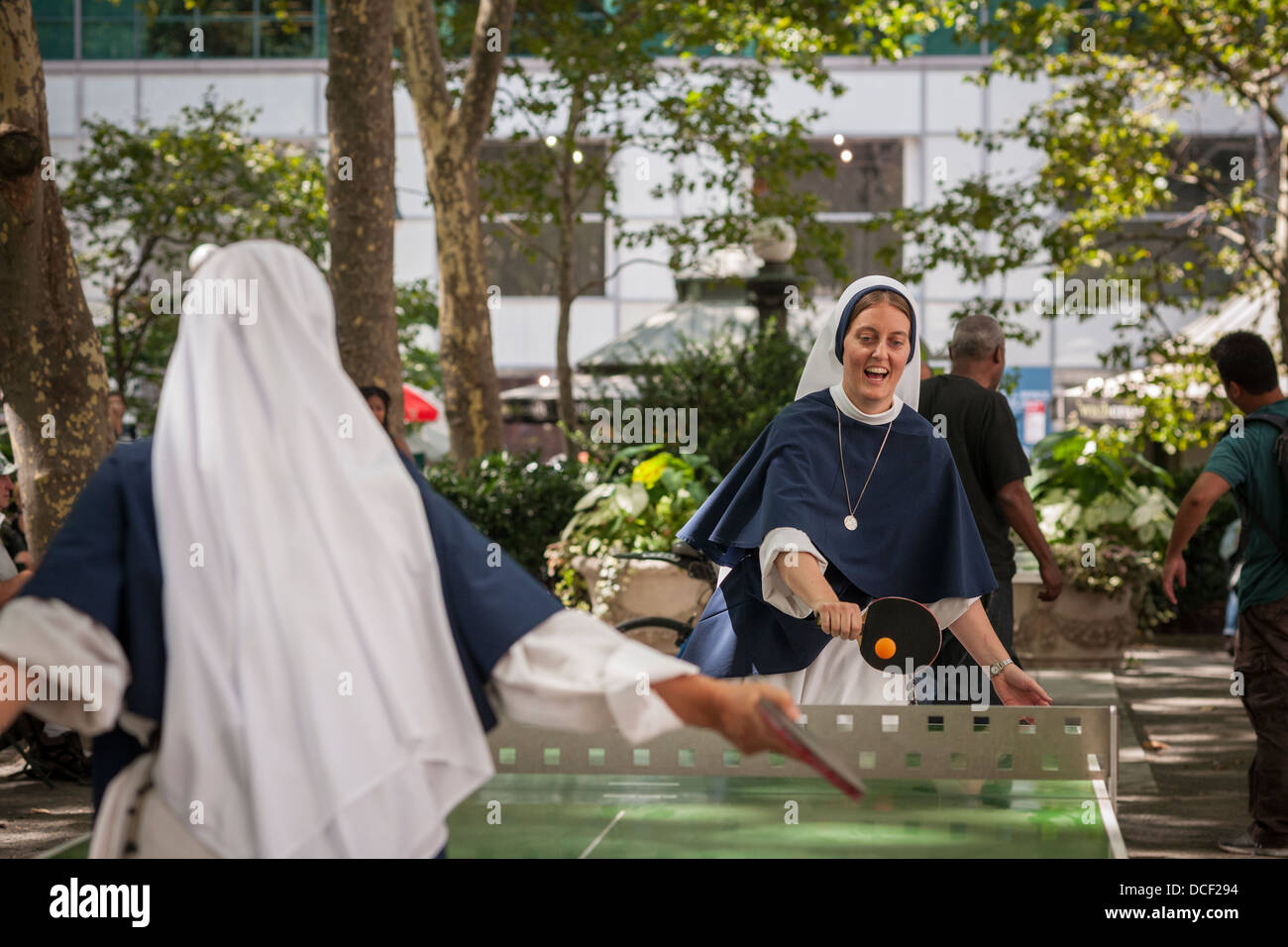 Nonnen von den Schwestern der Lebensordnung der katholischen Kirche spielen eine energetische Partie Tischtennis im Bryant Park in New York Stockfoto