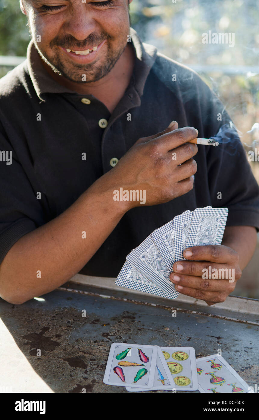 Mexikanische Mann Spielkarten und qualmender Zigarette; Guanajuato, Mexiko Stockfoto