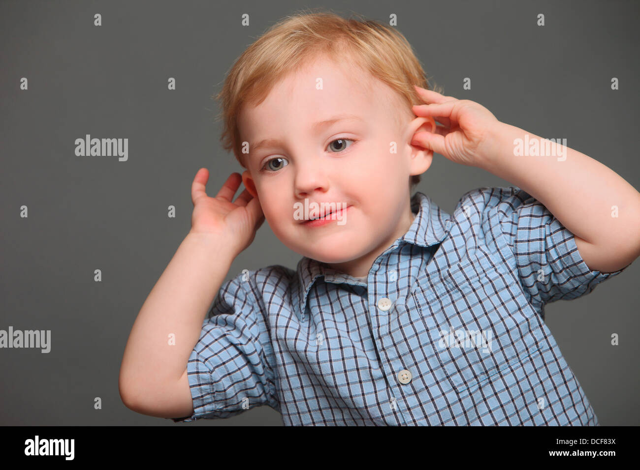 Junge zieht seine Ohren Stockfoto