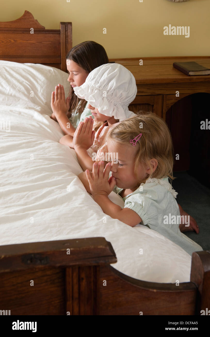 Drei Schwestern tun ihre gute-Nacht-Gebete Stockfoto