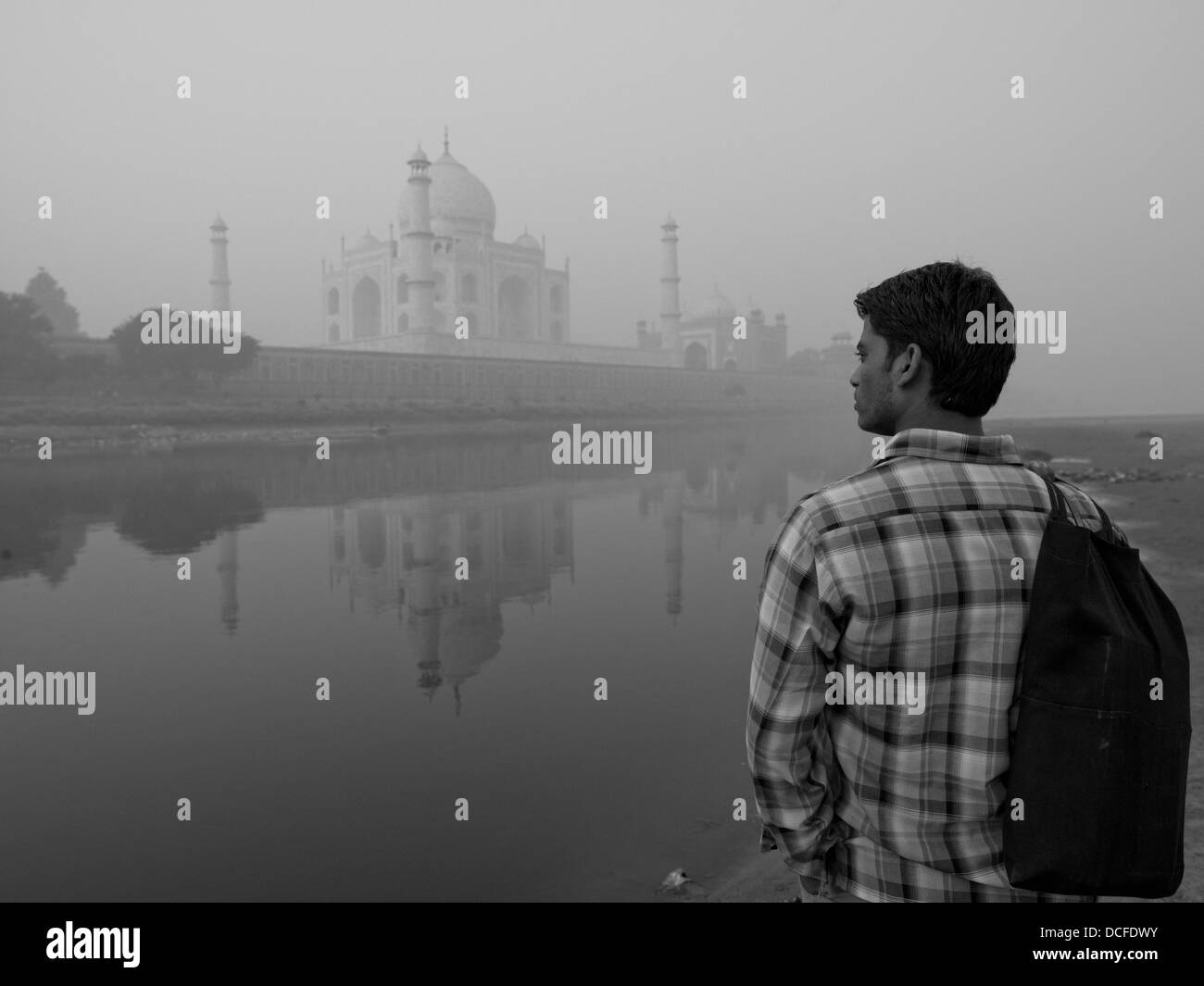 Taj Mahal, Agra, Indien; Junger Mann stand am Wasserrand, Blick auf das Taj Mahal Stockfoto