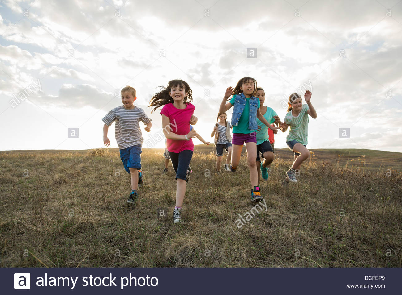 Begeistert Kinder laufen auf Hügel Stockfoto
