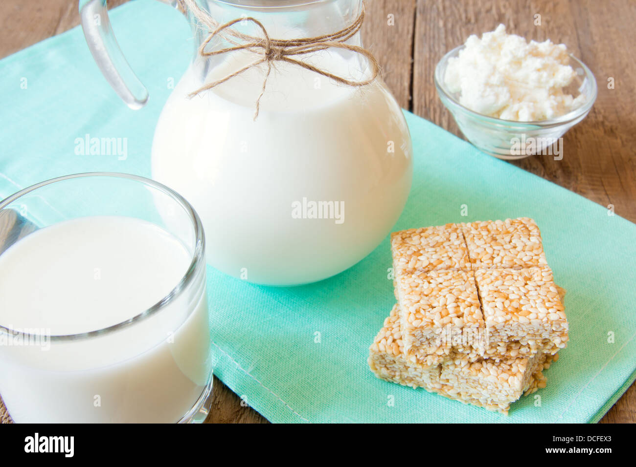 Kalzium-frische Milchprodukte-Set: Milch, Sesam, Hüttenkäse auf Serviette und Holztisch, Nahaufnahme, Horizontal Stockfoto
