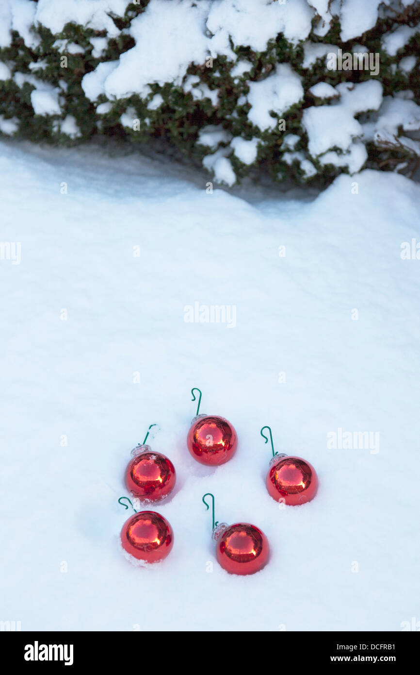 Rote Weihnachtskugeln im Schnee; Whitburn, Tyne And Wear, England Stockfoto