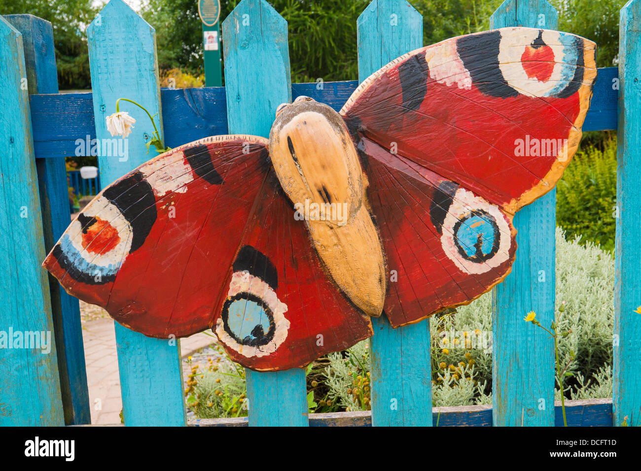 Hölzerne Schmetterling hängt an einem Tor. Stockfoto