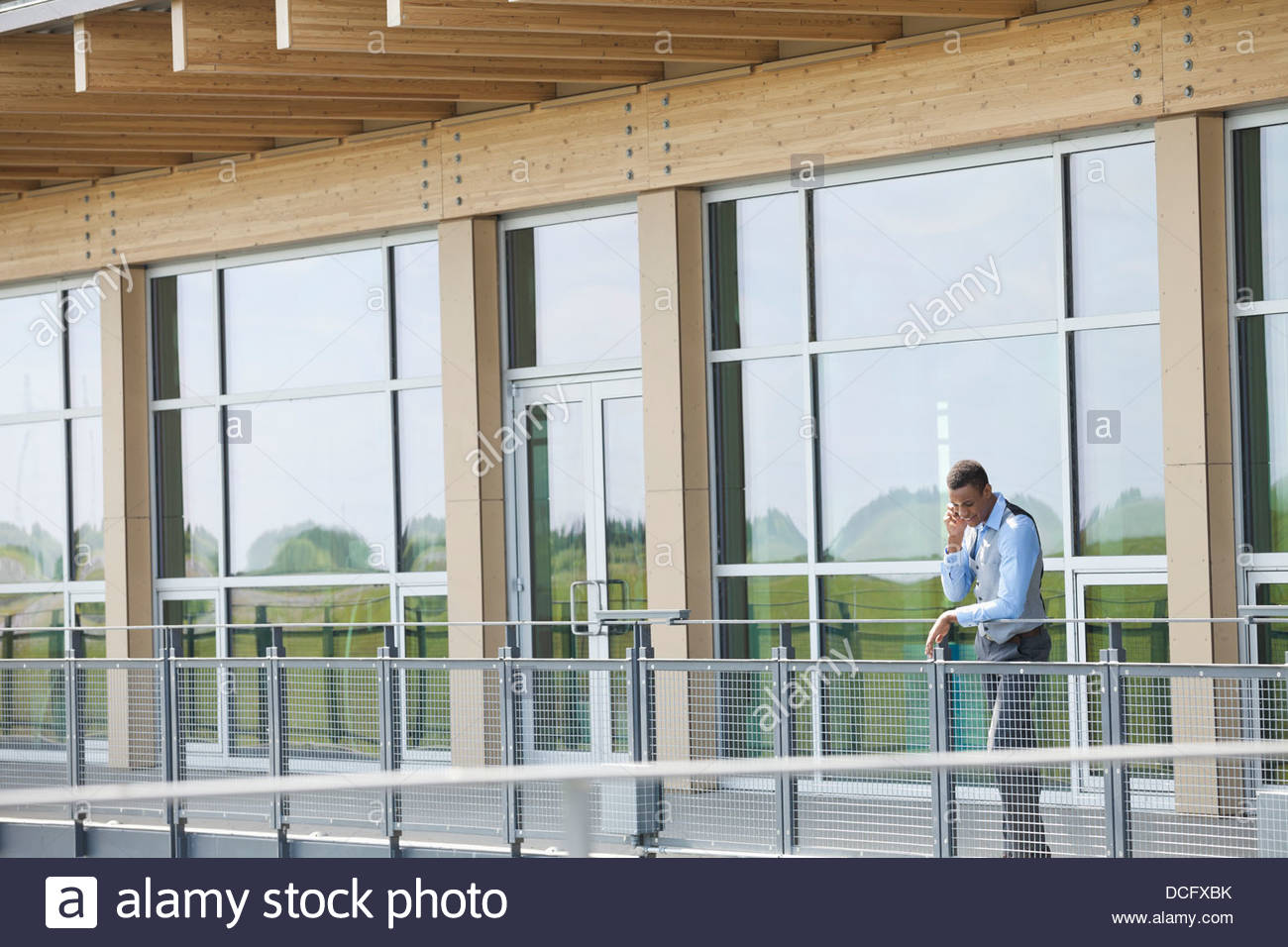 Geschäftsmann mit Handy auf Balkon Stockfoto