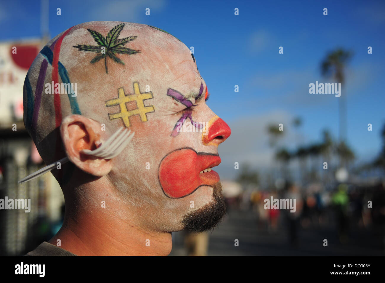 USA Kalifornien CA Los Angeles Los Angeles LA Venice Beach Porträt eines Mannes mit Make-up auf dem Kopf und einer Plastik Gabel durch sein Ohr Stockfoto