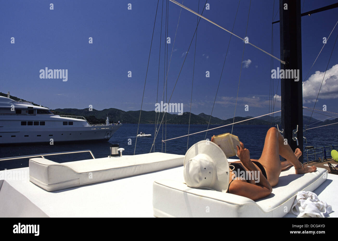 Eine Frau in einen Hut mit Krempe Sonnenbaden auf einer Yacht in Marmaris Meer Türkei Stockfoto