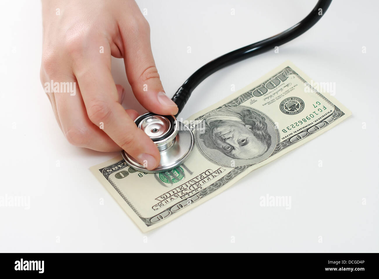 Arzt Holding Stethoskop gegen hundert US-banknote Stockfoto