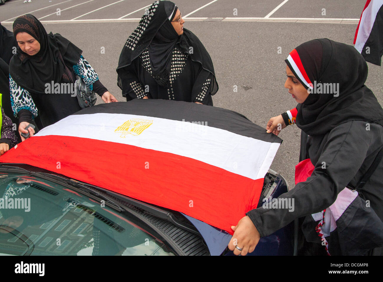 London, UK. 17. August 2013.  Frauen binden eine Flagge auf der Vorderseite eines Autos als über 100 britischen Ägypter vorbeifahren Protest auf den Straßen von London gegen den Militärputsch und anschließende Gewalt in Ägypten Credit halten: Paul Davey/Alamy Live News Stockfoto