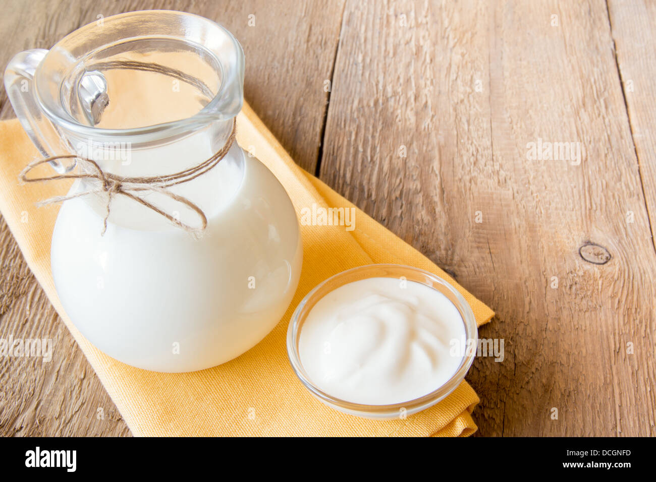 Calcium frische Milchprodukte: Milch und Sauerrahm (Joghurt) auf Serviette und Holztisch, Nahaufnahme, Horizontal, Textfreiraum Stockfoto