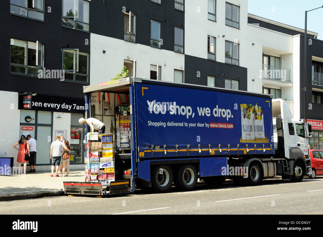 Tesco LKW oder Lieferwagen vor dem Laden, mit Menschen im Hintergrund, London Borough of Tower Hamlets, England Großbritannien Stockfoto